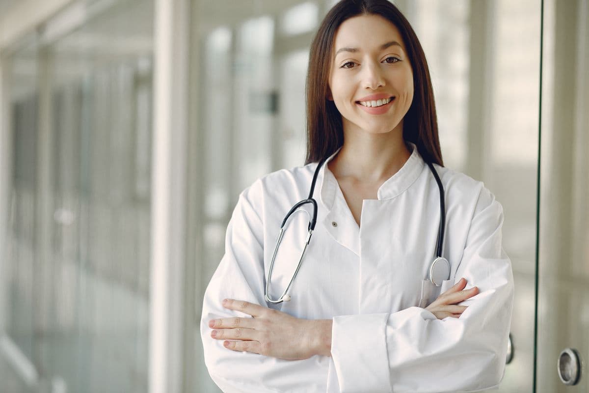 Smiling doctor in a white coat with stethoscope in a hospital