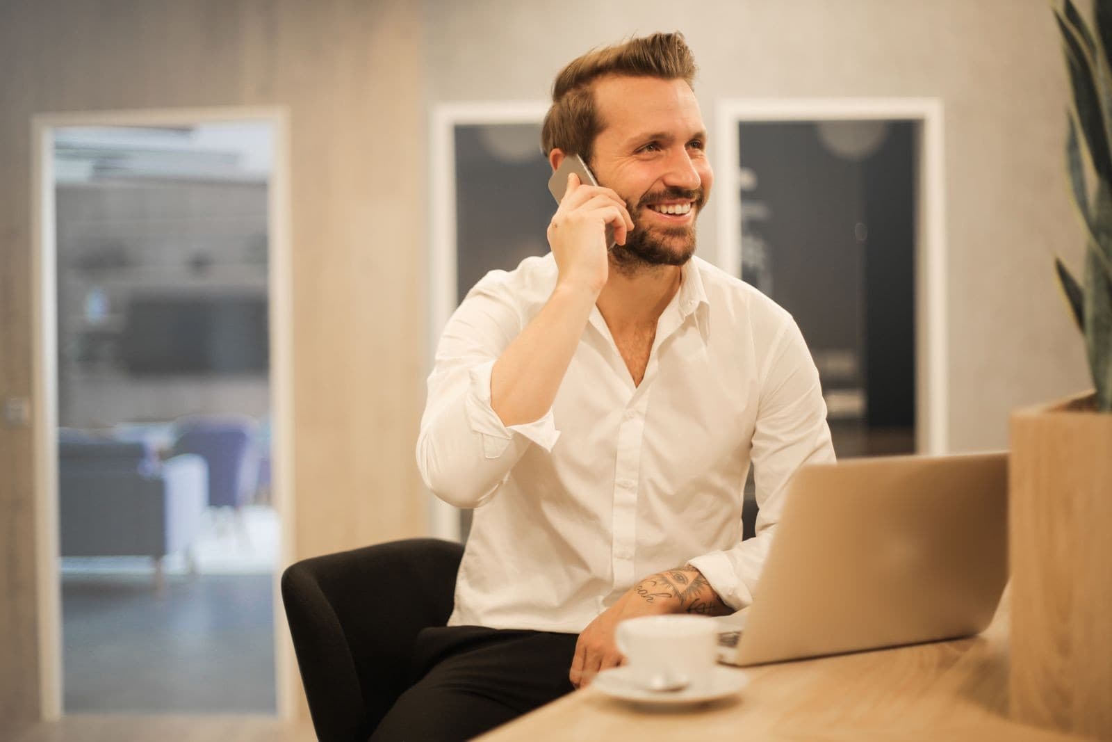Insurance agent smiling while taking a client call at his desk